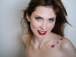 Young  beautiful positive  woman  with  professional  makeup .  St.  Valentine style with hearts 