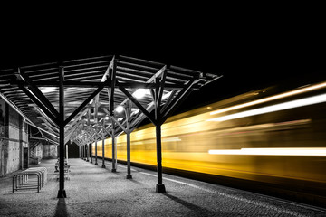 Yellow train departure from the railway station in the evening.