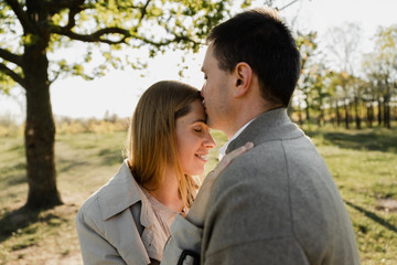 Fototapeta premium husband tenderly kisses his wife on the forehead,pregnant wife hugs husband