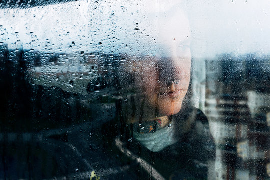 Depressed man looking through window