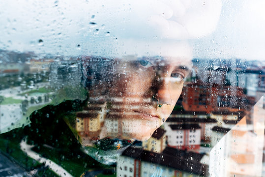 Depressed man looking through window