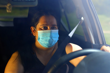 Driver with respirator driving car. Protective clothing against pollen allergy and infections. Traffic safety theme. Transportation in coronavirus time.