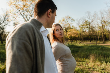 Husband with his pregnant wife walking in park,portrait of a pregnant couple,future parents,happy young family is pregnant