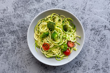 Homemade Zucchini Spaghetti with pesto sauce, broccoli and cherry tomatoes from above. Vegan food concept.Flat lay.Top view