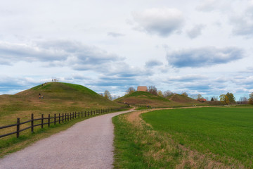 Fototapeta na wymiar The Royal Mounds (Kungshogarna) three large barrows located in Gamla Uppsala. Archeological site in Sweden near Stockholm.
