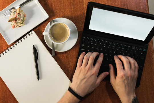 Freelancer sitting at cafe table and browsing laptop