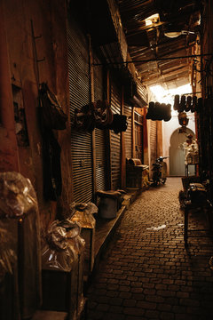 Typical empty narrow covered street with closed shops in local bazaar in ancient city Marrakesh in Morocco