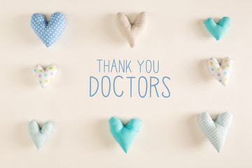 Thank You Doctors message with blue heart cushions on a white paper background