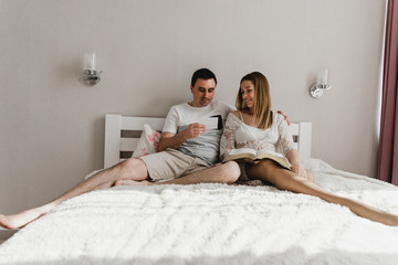 Fototapeta premium Happy young woman doing pregnancy test while sitting apart from husband in room