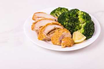Chicken grilled fillet filled with julienne, lemon and steamed broccoli. Healthy food, ketogenic diet. Keto/Paleo