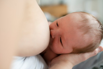 Obraz na płótnie Canvas mother in her bedroom breastfeed her baby.