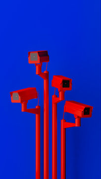 Red surveillance camera on blue background monitoring people on the street. Camera to search for quarantine offenders caused by Coronavirus