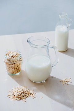 Jar of milk and oatmeal flakes on table