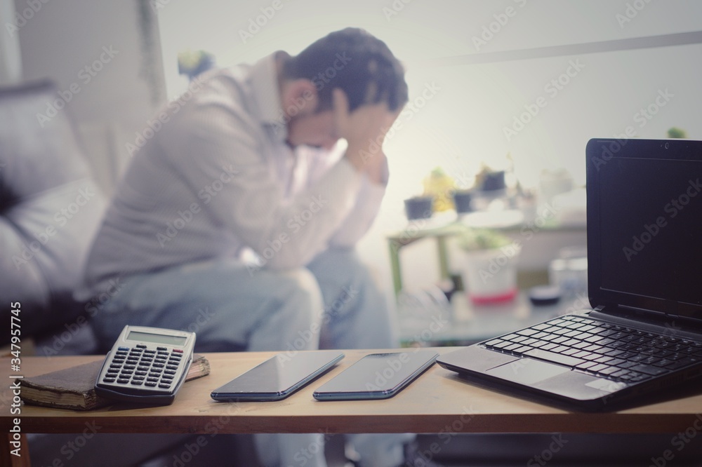 Wall mural man suffers from stress, anxiety and depression from overwork or telecommuting, cell phones, compute