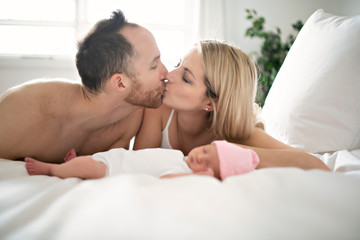 A family parent with a newborn baby in bed