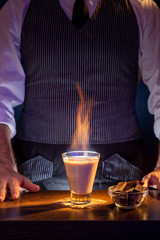 Bartender serving cocktail on fire