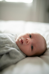 Cute newborn baby girl on the white bed
