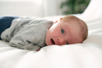 Cute newborn baby girl on the white bed