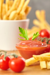 French fries with ketchup on wooden background. Close up.