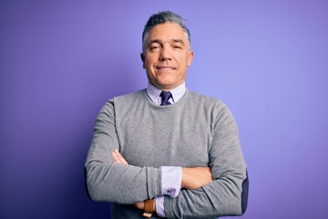 Middle age handsome grey-haired man wearing elegant sweater over purple background happy face smiling with crossed arms looking at the camera. Positive person.