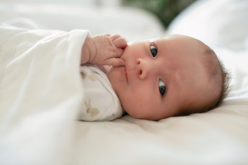 A Sweet newborn baby girl sleeping in white bed