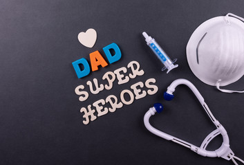 The concept of doctors, health and medical nurses. Father's Day or anniversary with wood table background, with toys doctor accessories, stethoscope,  medical injection, and face mask.