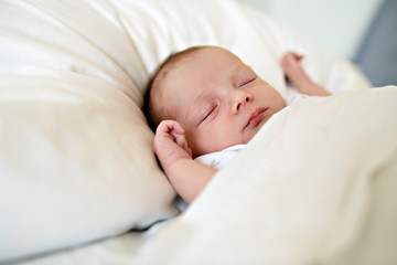 A Sweet newborn baby girl sleeping in white bed