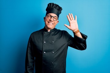 Middle age handsome grey-haired chef man wearing cooker uniform and hat Waiving saying hello happy and smiling, friendly welcome gesture