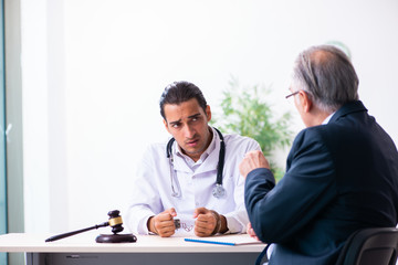 Male doctor in courthouse meeting with lawyer