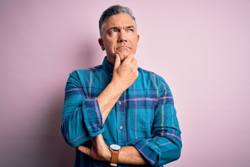 Middle age handsome grey-haired man wearing casual shirt over isolated pink background with hand on...