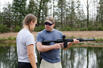 Shooting instructor teaching a young woman.