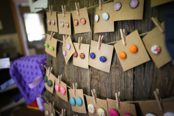 Colorful earrings on rustic wooden board for sale at market