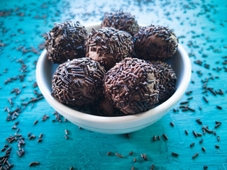 Brigadeiro.Traditional Brazilian sweet. Blue background with scattered chocolate sprinkles