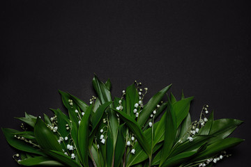Spring flowers lily of the valley on a black background background. Copy space