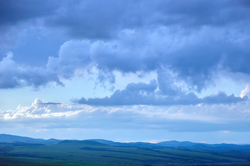 Rain clouds over distant hills at sunset. Zabaykalsky Krai. Russia.