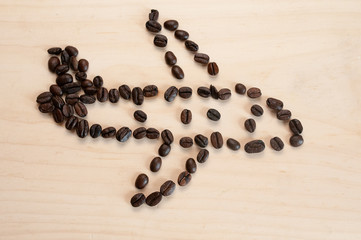 The figure of the plane is made of roasted coffee beans on a light background, there is room for text.