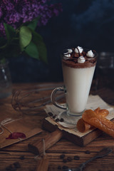Caffe latte on dark moody background with flowers. - 347973948