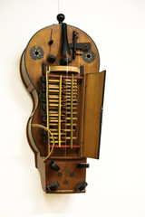Ornate wooden stringed instrument known as hurdy gurdy.