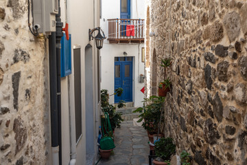 Narrow street in old town. Beautiful street with white buildings in Mandrakion Greece.