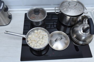 Ravioli in pan, boiling water, silver metal background. Cooking Pelmeni, russian dumplings stuffed...