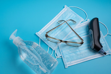 Fototapeta na wymiar Face mask, thermometer , sanitizer gel and glasses. Corona virus concept.