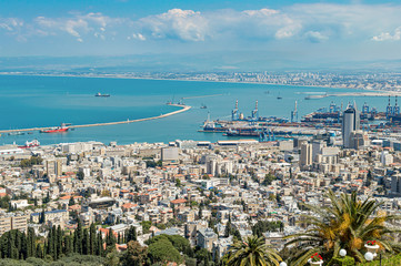 Fototapeta premium Port city with infrastructure on a background of mountains and sea