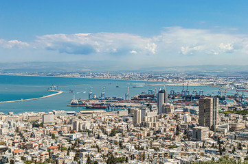 Port city with infrastructure on a background of mountains and sea