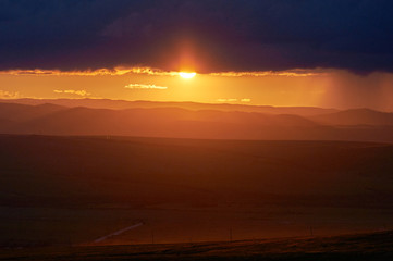 Rain over the distant hills at sunset. Zabaykalsky Krai. Russia.