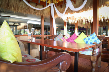 Vibrant colorful cushions in outdoor bungalow eating area restaurant at resort