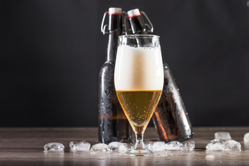 A glass of light beer is on the table with ice. The concept of relaxation, bars and parties