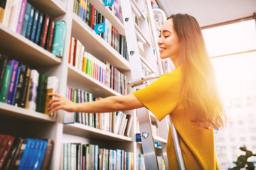 Girl choose a book to read. Concept of culture and studying.