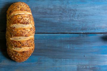 Artisan seed bread on a blue table, ideal for tapas or sandwiches