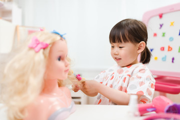 Obraz na płótnie Canvas toddler girl pretend play as hairdresser at home