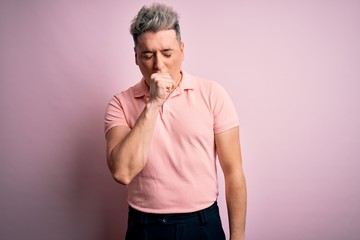 Young handsome modern man wearing casual pink t-shirt over isolated background feeling unwell and coughing as symptom for cold or bronchitis. Health care concept.